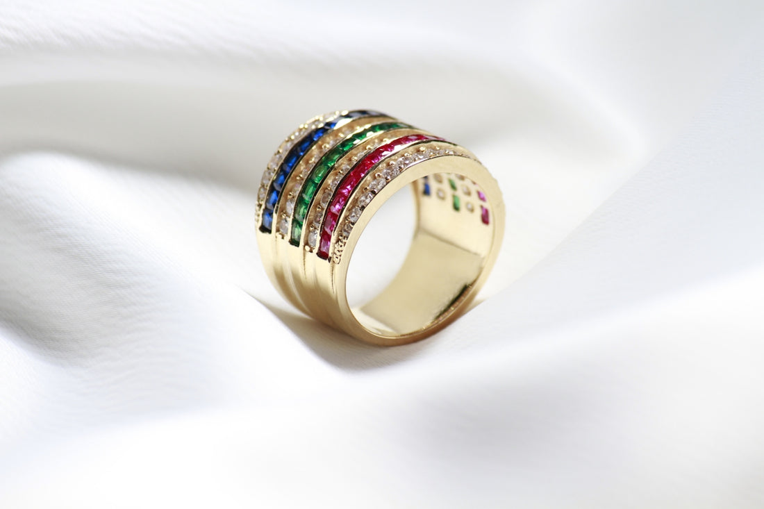 a gold ring with five different colored stones