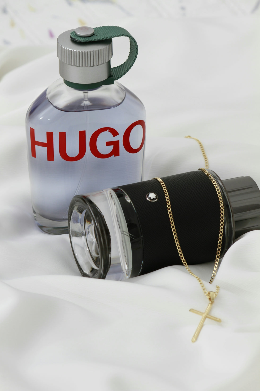 A bottle of perfume sitting on top of a bed