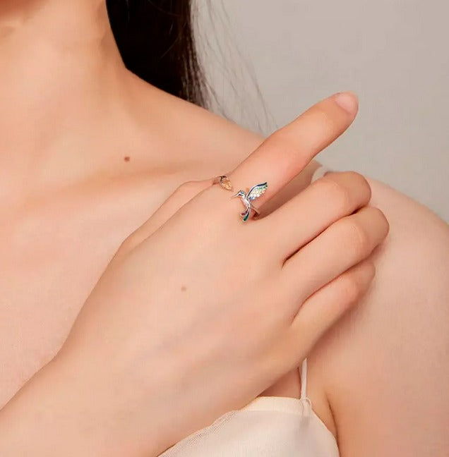 Mujer posando con anillo de plata con diseño de colibrí